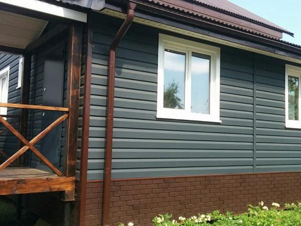 Серый металлический сайдинг на стене загородного дома стена дома из металлического сайдинга